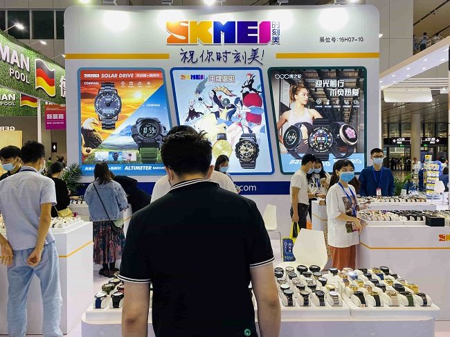The SKMEI stand at a trade fair, visitors at the display cases.