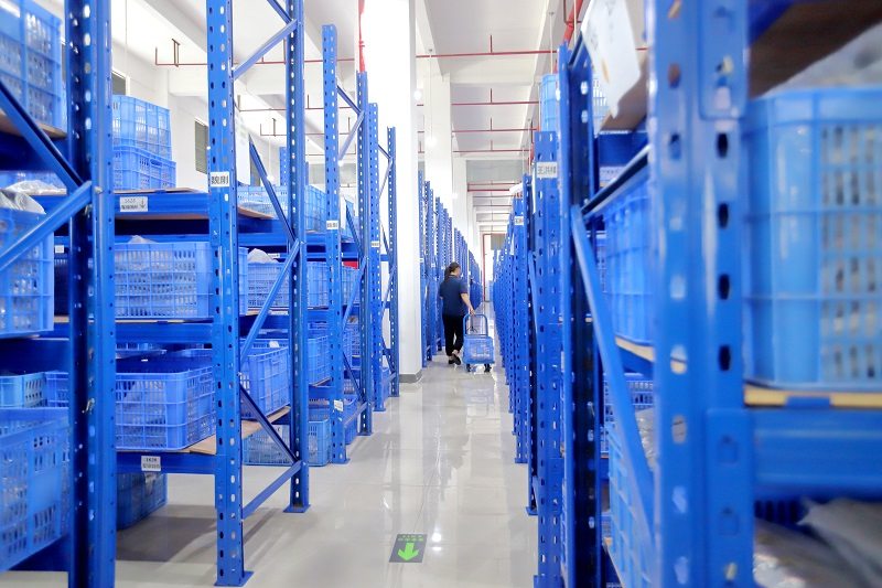 The warehouse, blue racking running the length of the aisle. SKMEI states it holds more than 6000 SKU in perennial stock.